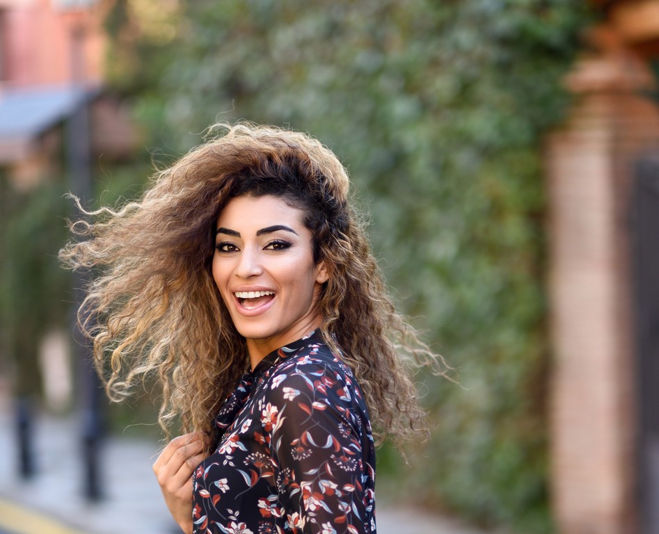 Mulher com corte de cabelo repicado em camadas, cacheado