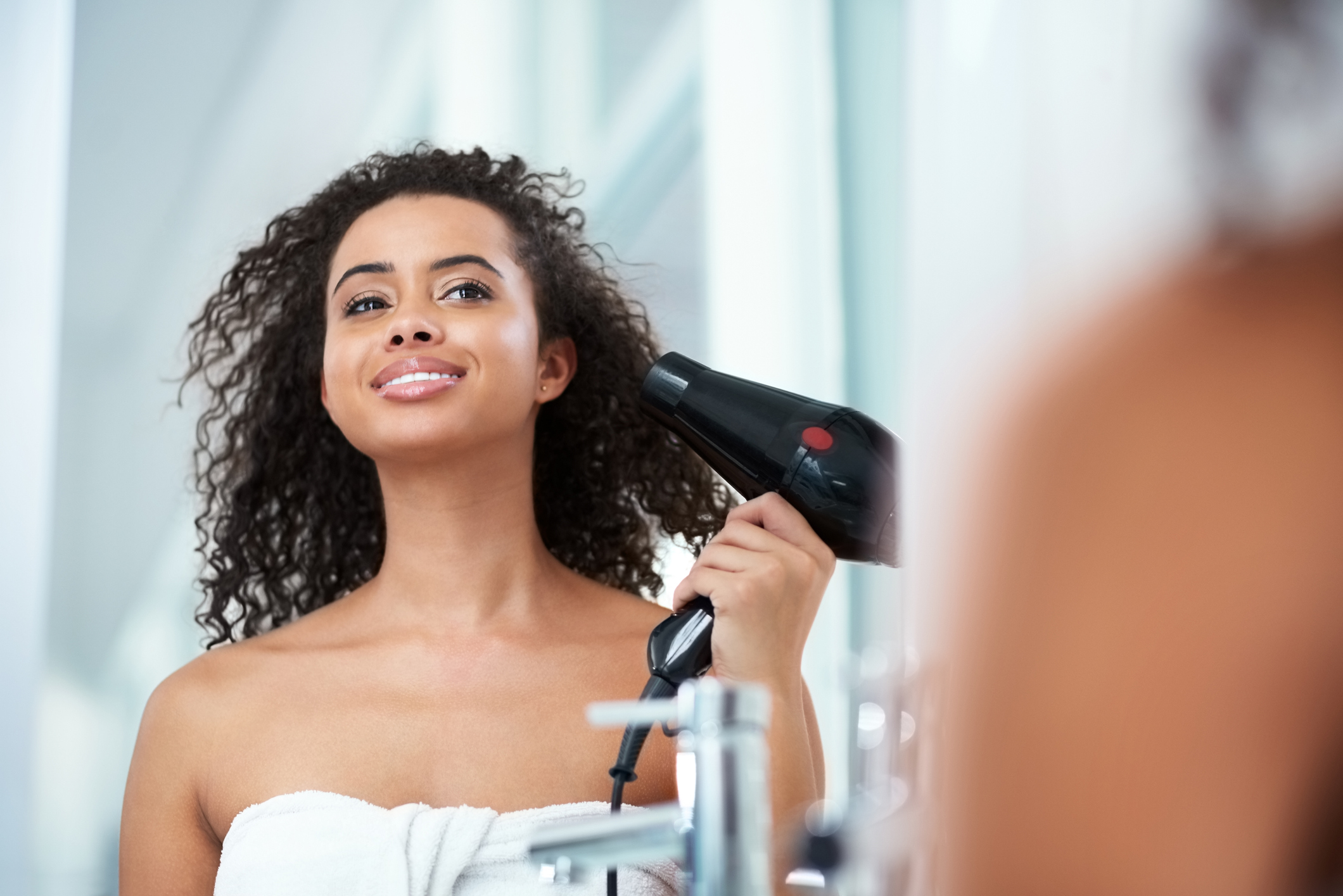 Cabeleireiro seca o cabelo com secador de cabelo para uma mulher